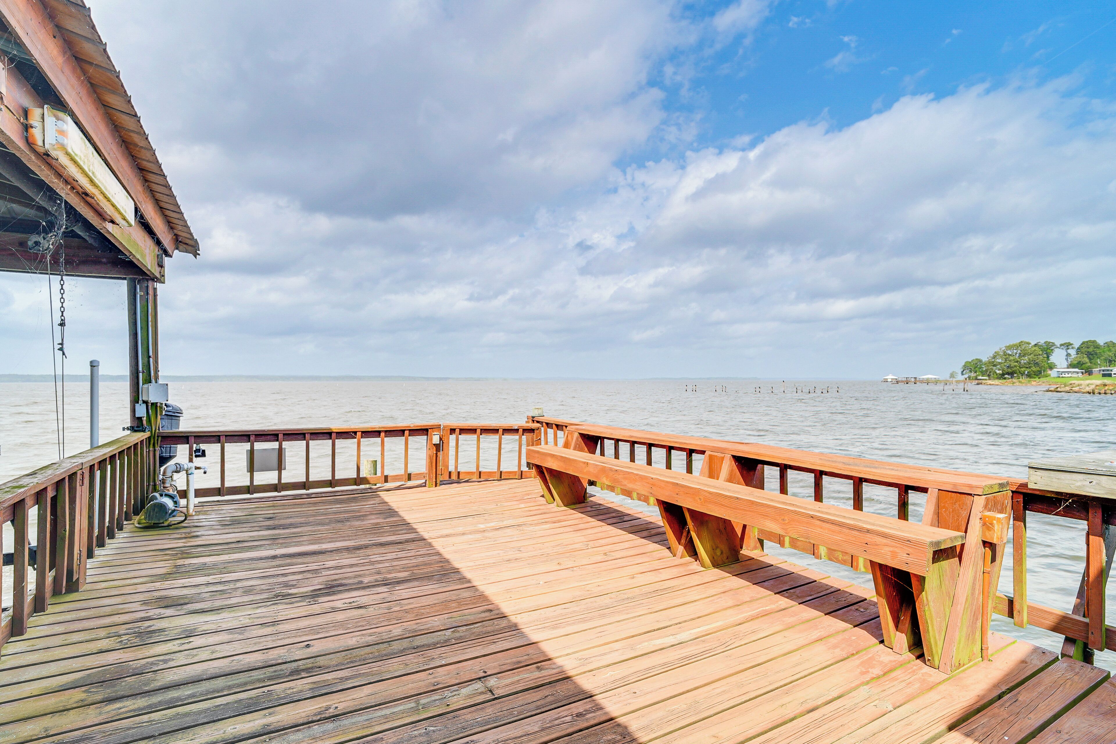 Un muelle de madera que se adentra en el agua bajo un cielo nublado.