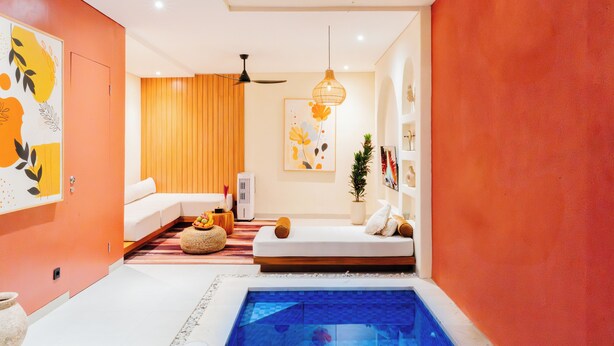 A modern living room with a pool, a ceiling fan, and a large artwork on the wall. - Exquisite 2 Bedroom Retreat Nestled In The Serene Pecatu (pecatu)