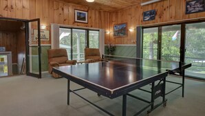 A ping pong table in a room with wooden walls and large windows. - Indoor Pool, Hot Tub, Storyland (Bartlett)