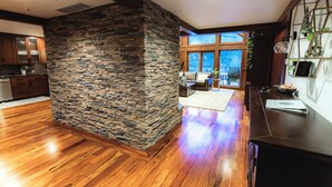 A modern kitchen with wooden cabinets and a stone accent wall.