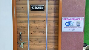 A wooden door with a sign reading "KITCHEN" and a sign offering free Wi-Fi on the ground floor. - Prem Bhawan Guset House (Danta Ramgarh)
