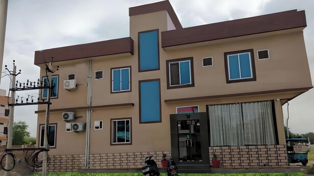 A two-story building with a flat roof, multiple windows, and a visible entrance with a door and a small overhang. - Prem Bhawan Guset House (Danta Ramgarh)