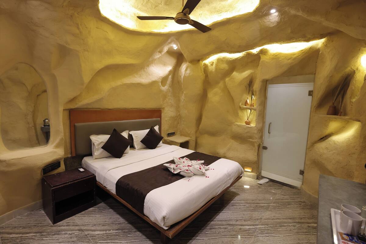 A bedroom with a bed, nightstands, a ceiling fan, and a door.