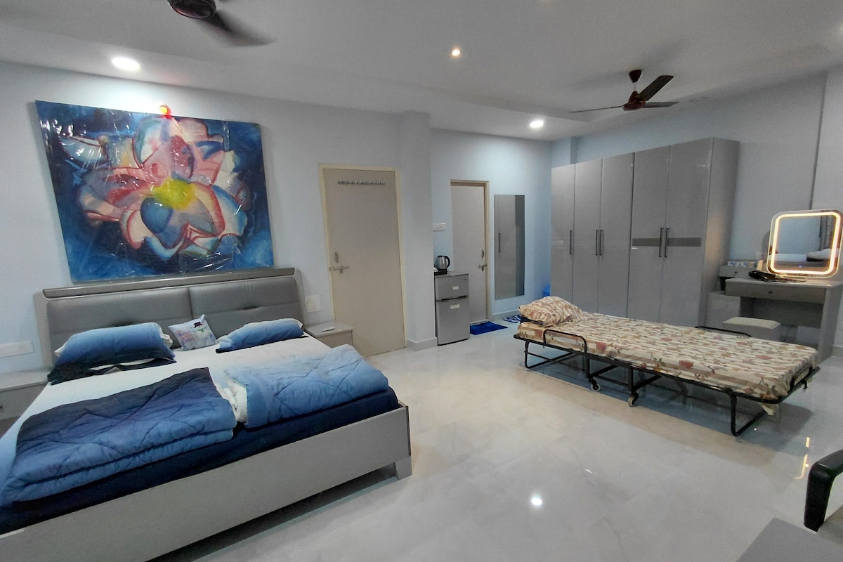 A modern bedroom with a bed, a bedside table, a wardrobe, and a large abstract painting.