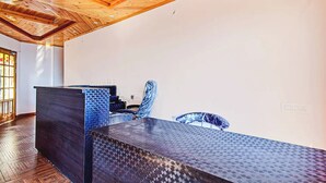 Una habitación moderna con techo de madera, un escritorio grande y una silla.