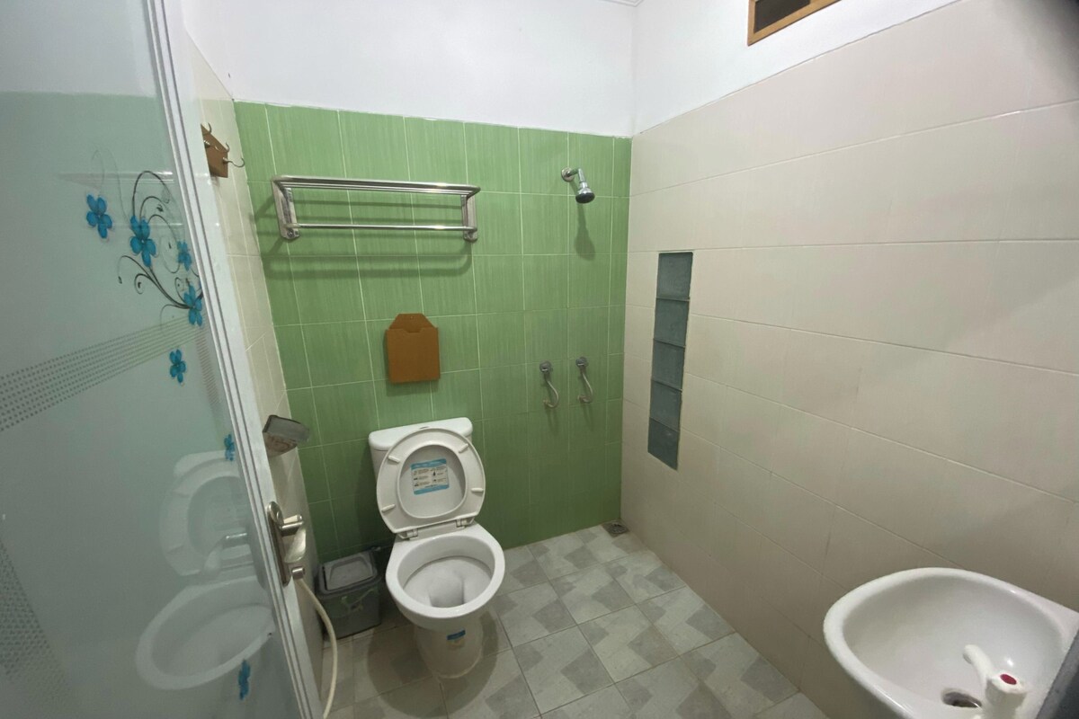 A bathroom with a toilet, bidet, and a shower area.