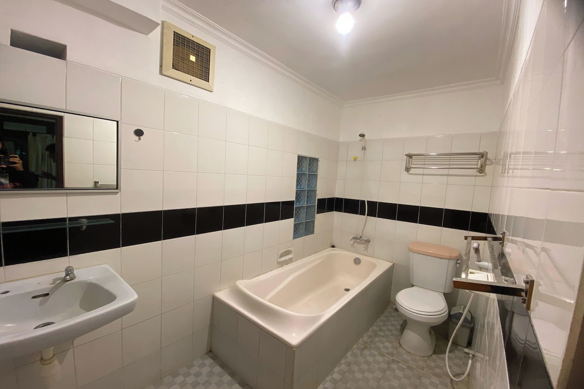 A bathroom with a bathtub, sink, toilet, and a mirror.