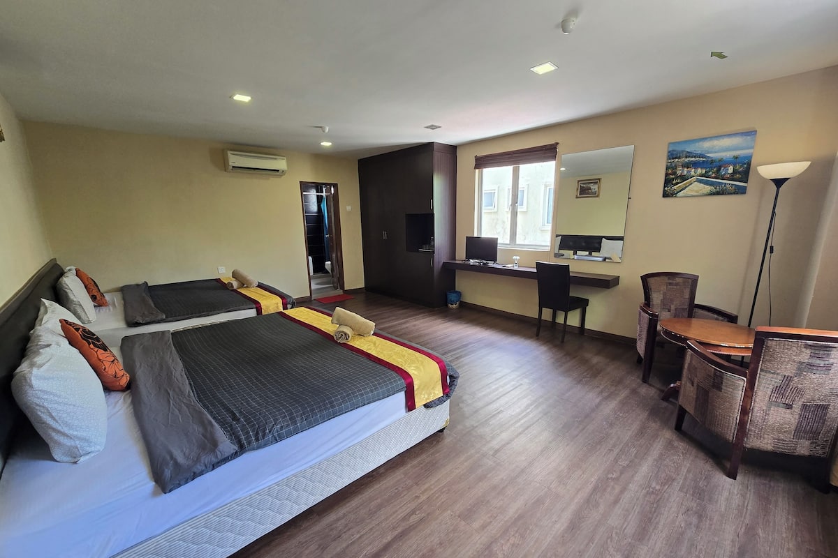 A hotel room with two beds, a desk, a chair, a lamp, and a window with a view.