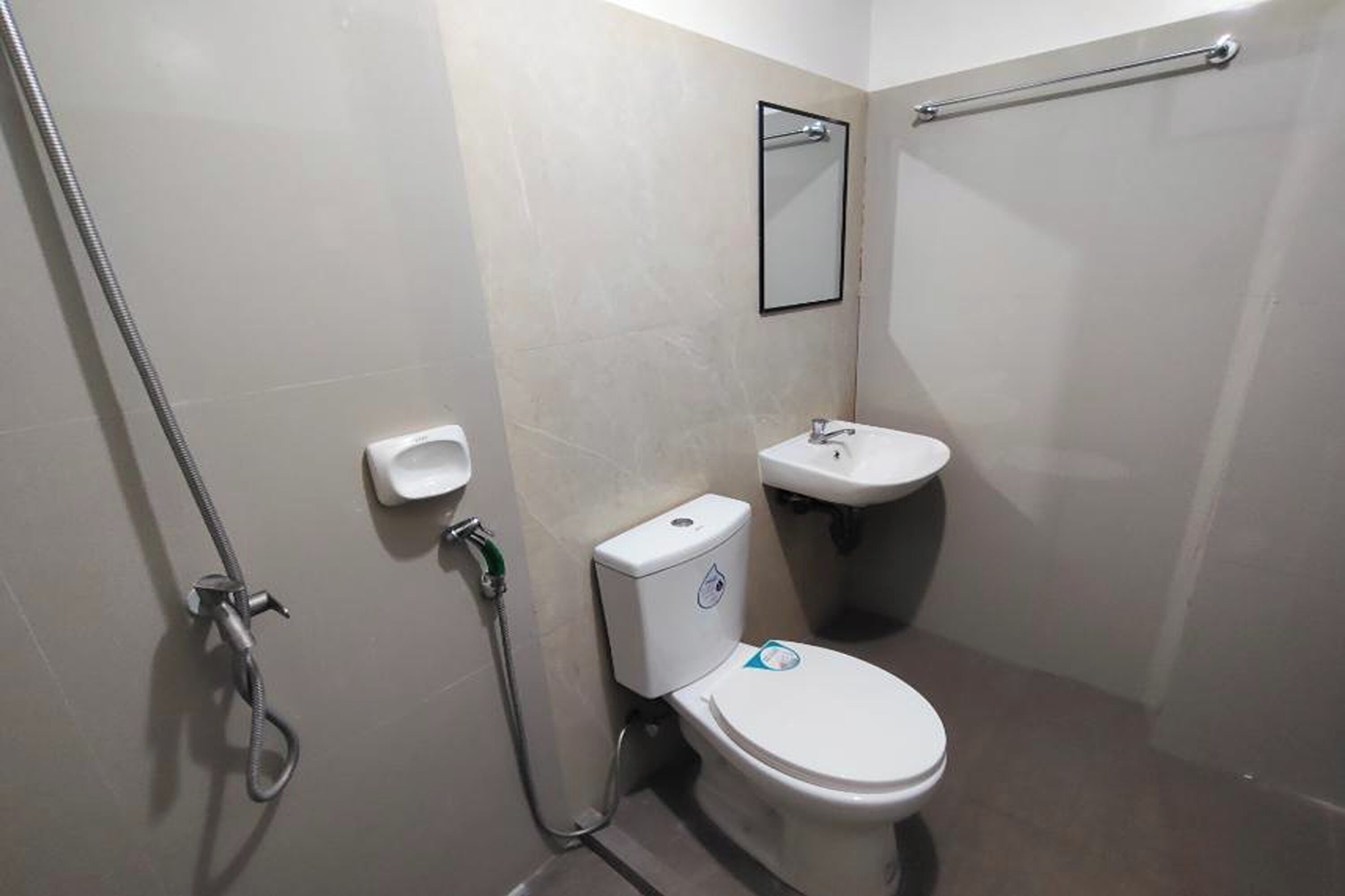 Un bagno moderno e piccolo, con il water, lavandino e doccia.