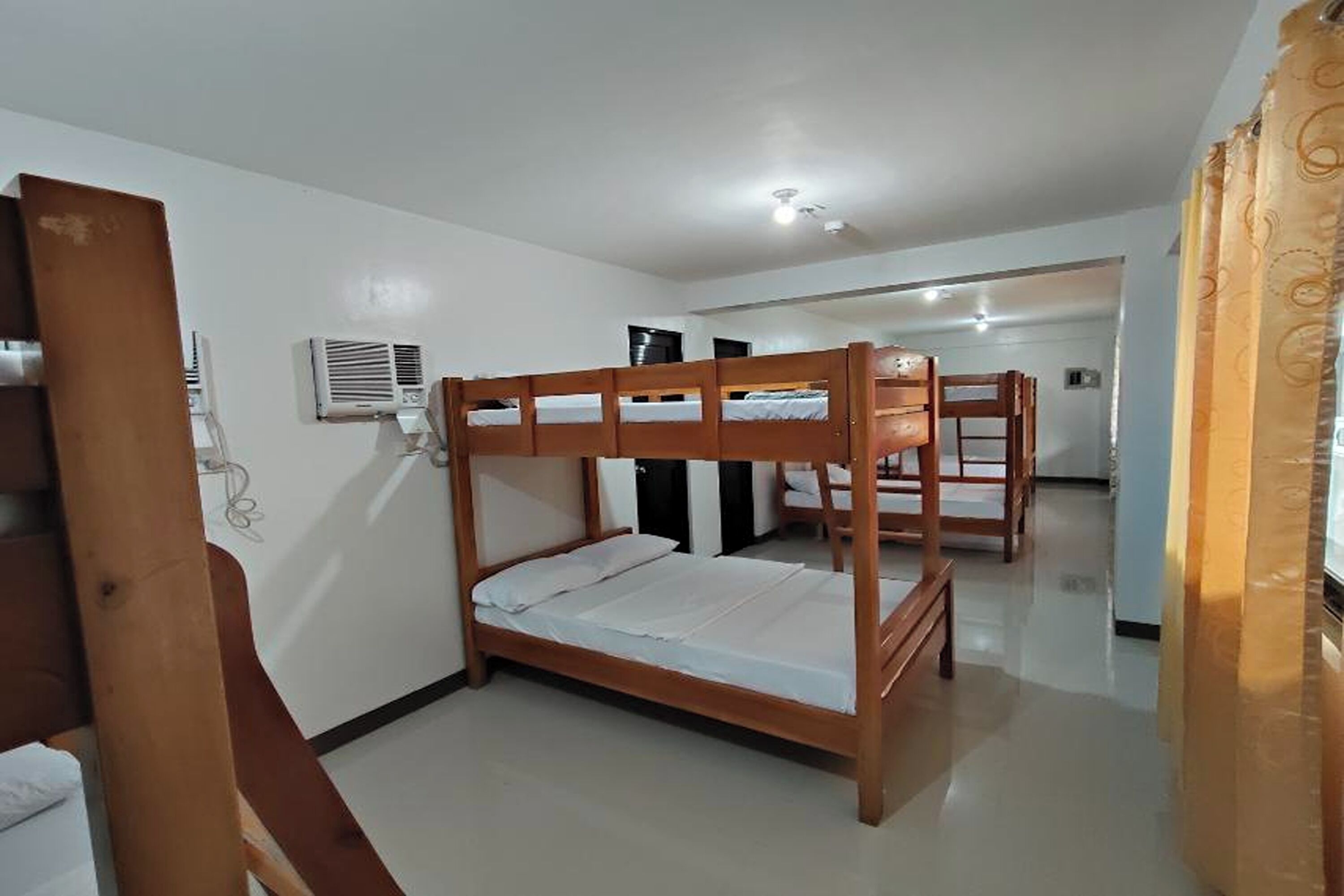 A room with a bunk bed, a desk, and a chair.