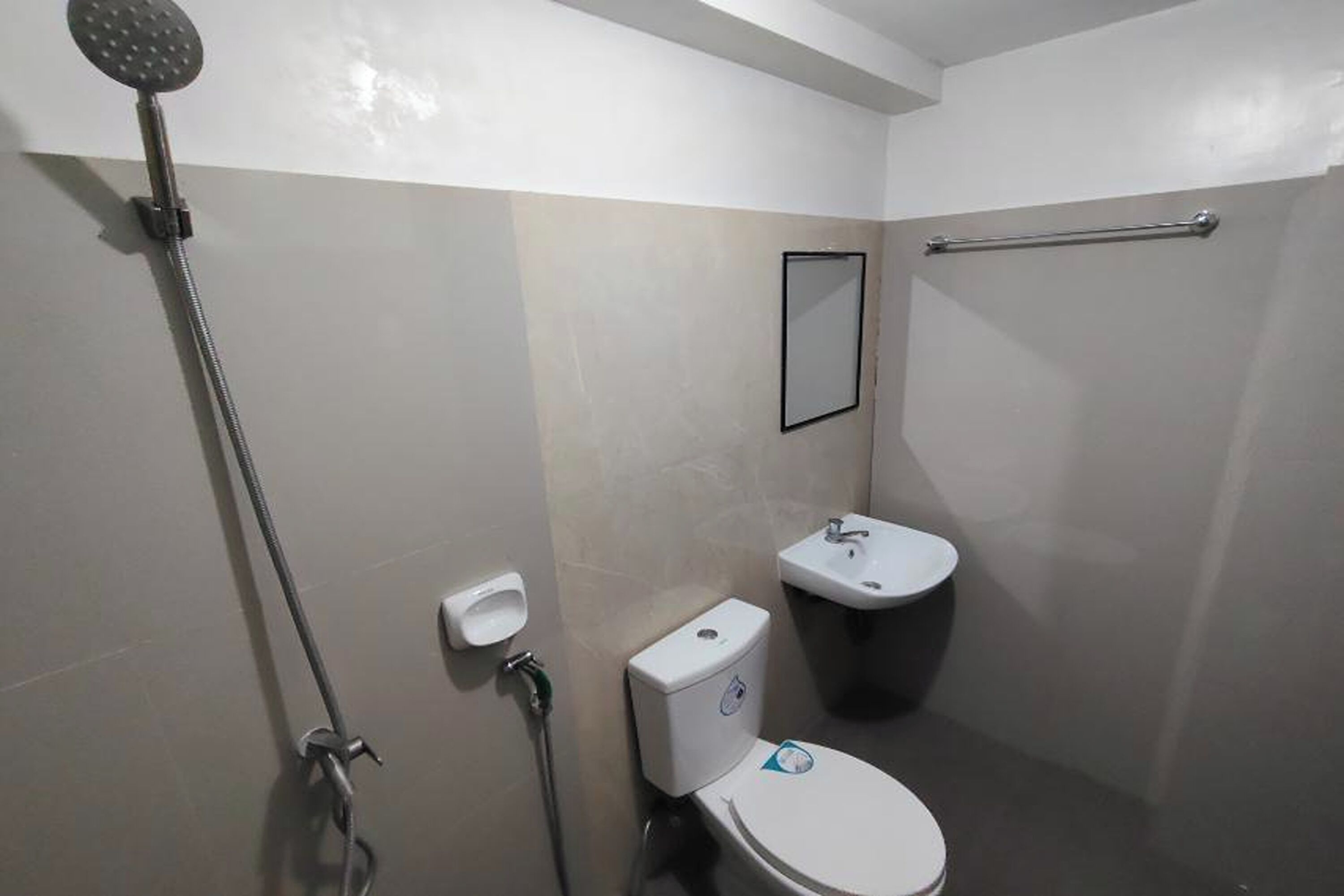Een compacte, schone badkamer met toilet, wastafel en douche.