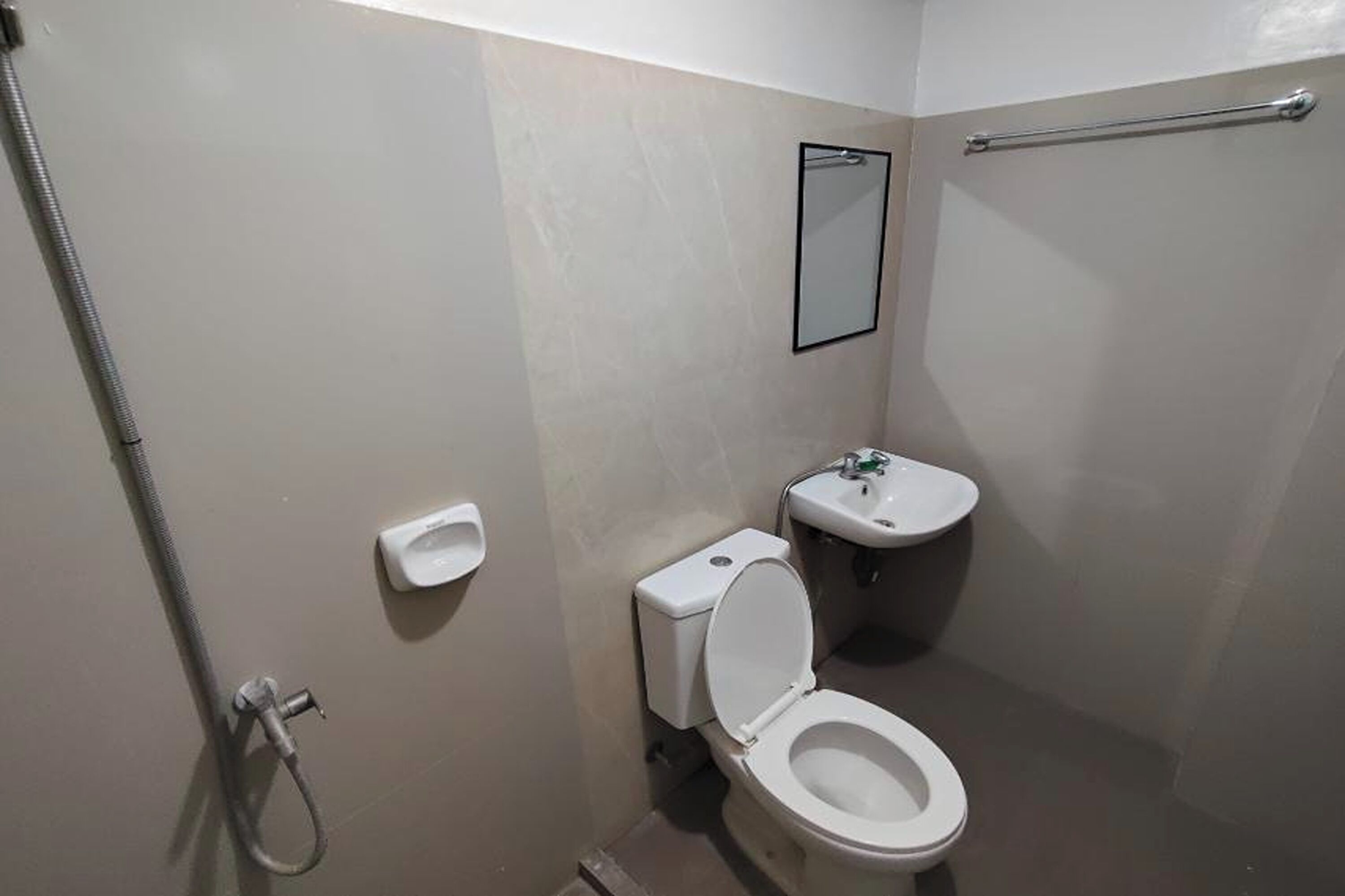 A small, compact bathroom with a toilet, sink, and shower.
