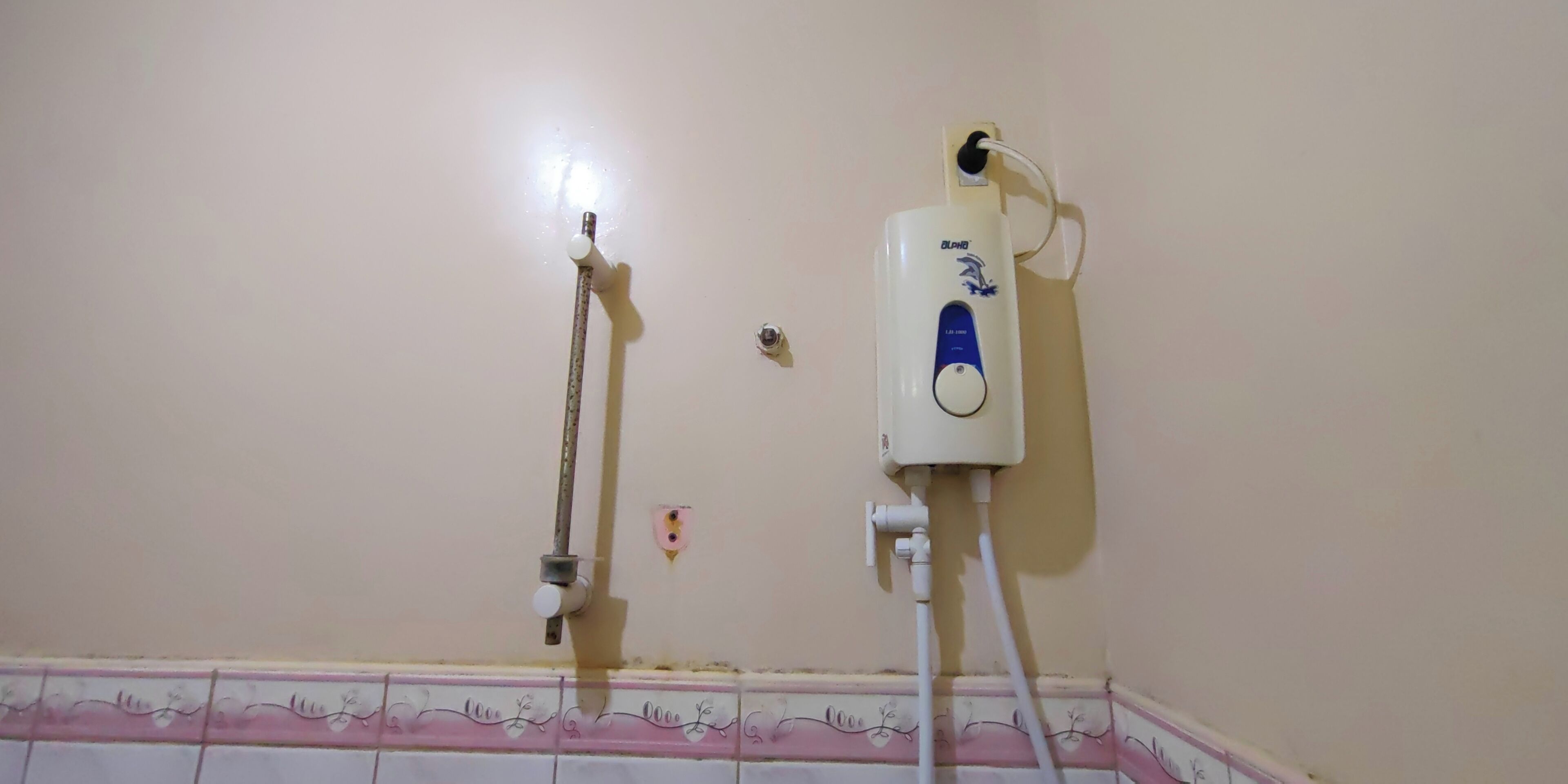 Ein Badezimmer mit Toilette, einem Bidet und einem an der Wand befestigten Warmwasserbereiter.