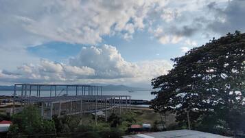 A coastal view with a large metal structure, possibly a construction site, and a body of water in the background.