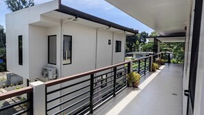 Een modern gebouw met een balkon, een witte gevel en een zwarte balustrade.