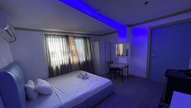 Een kamer met een bed, een bureau en een stoel.