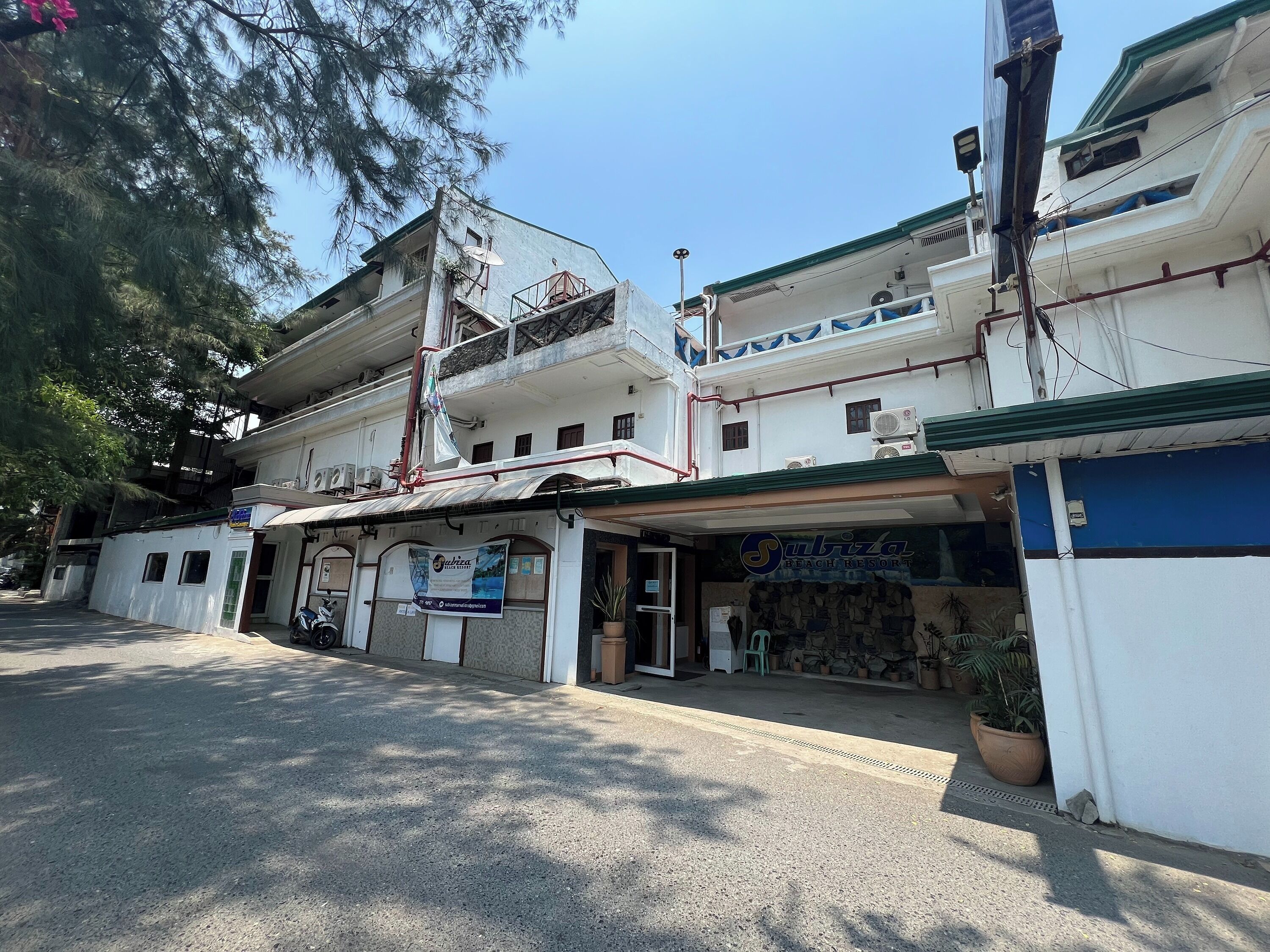 A two-story building with a sign for 'Subiza Beach Resort'.