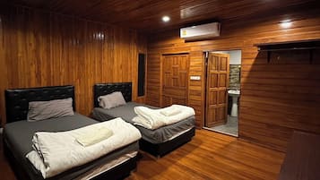 Een kamer met twee bedden, houten wanden en een houten vloer.