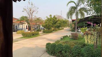 Una calle residencial con casas, un paseo techado y abundante vegetación.