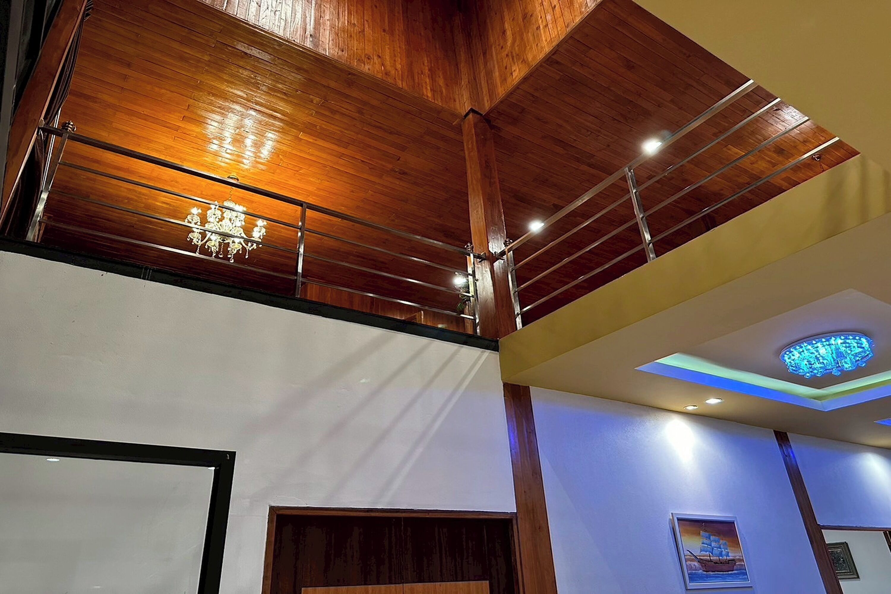 A high-ceilinged room with wooden beams and a chandelier.