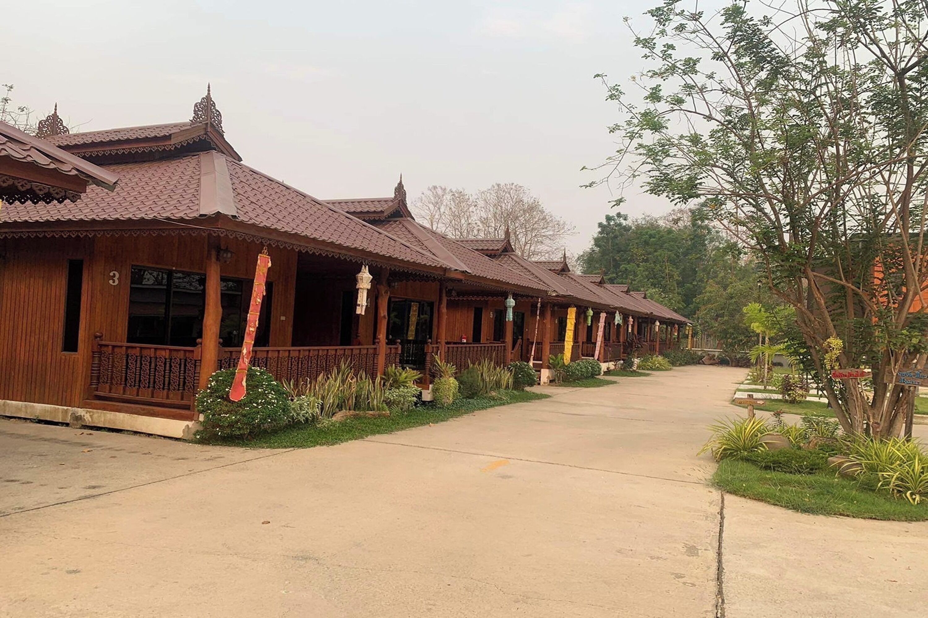 A row of traditional wooden buildings with tiled roofs and a paved pathway.