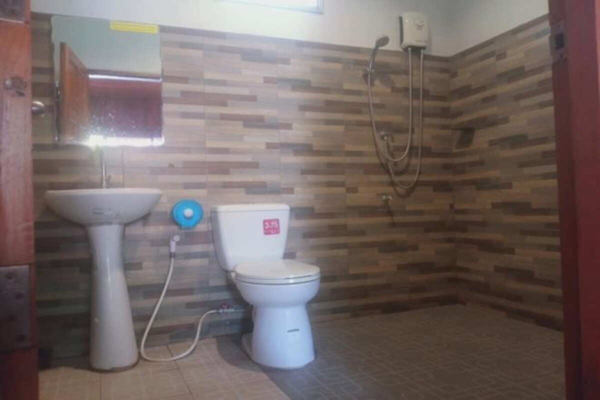 Een badkamer met toilet, wastafel en douche.