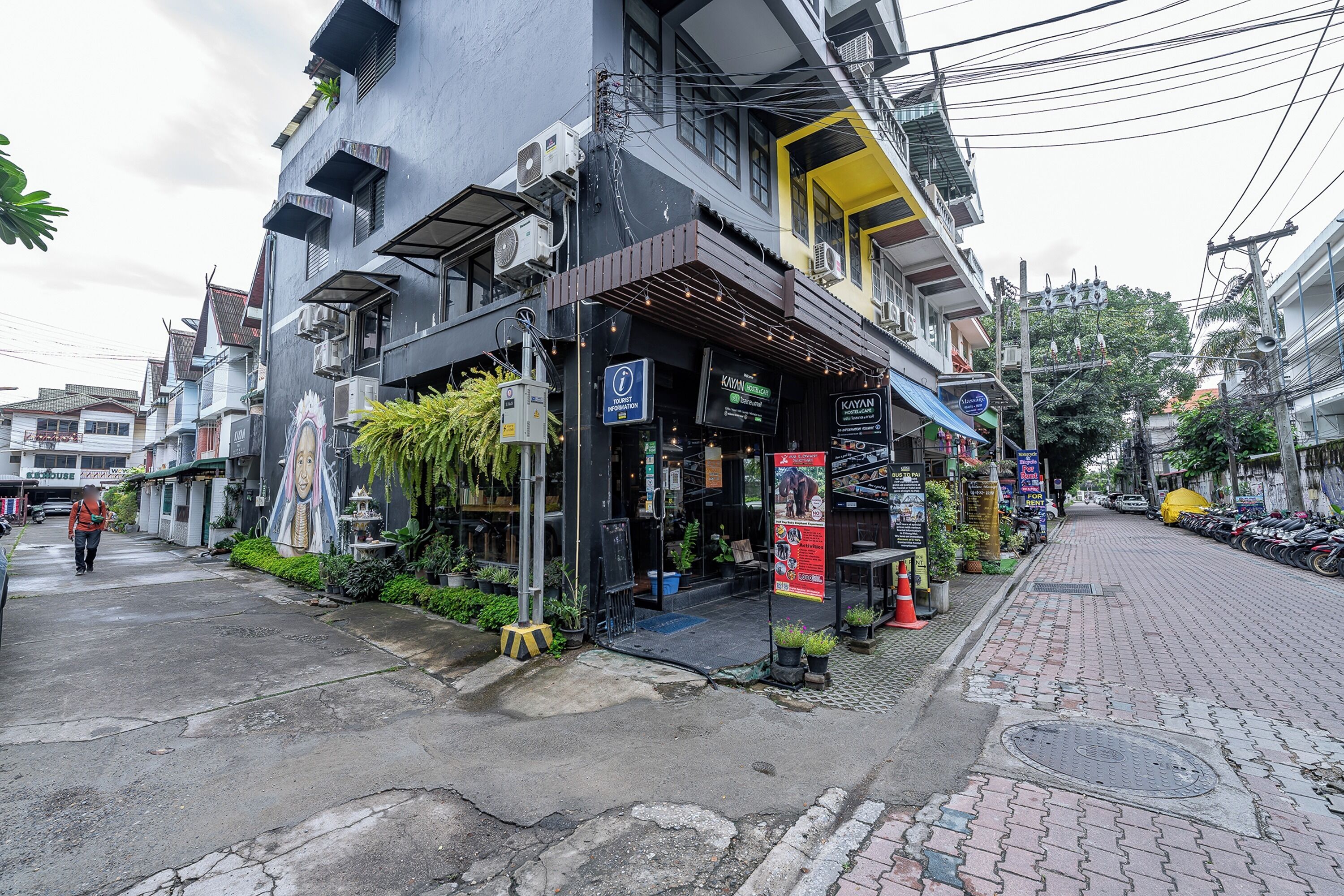 A street view with a building featuring a restaurant named "KAYAN" and a signboard for "KAYAN".