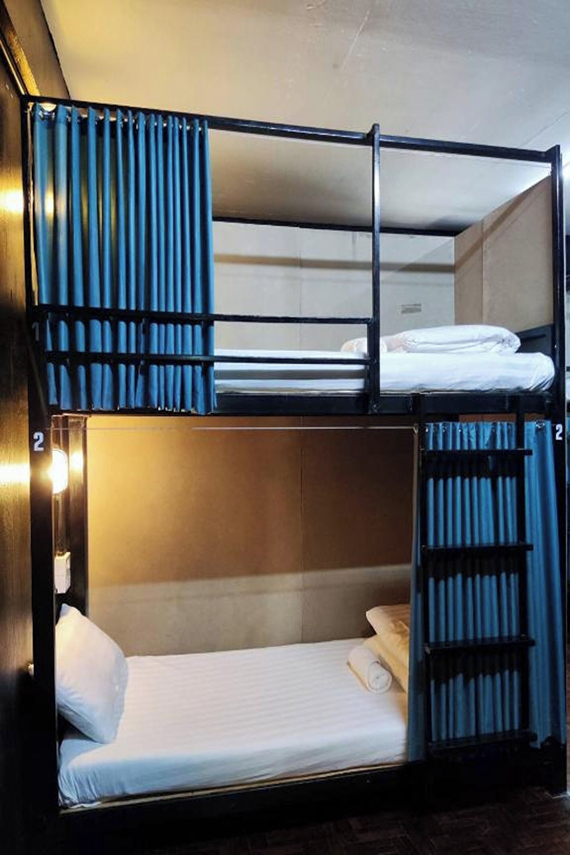 A bunk bed room with curtains, a number '2' sign, and a light fixture.