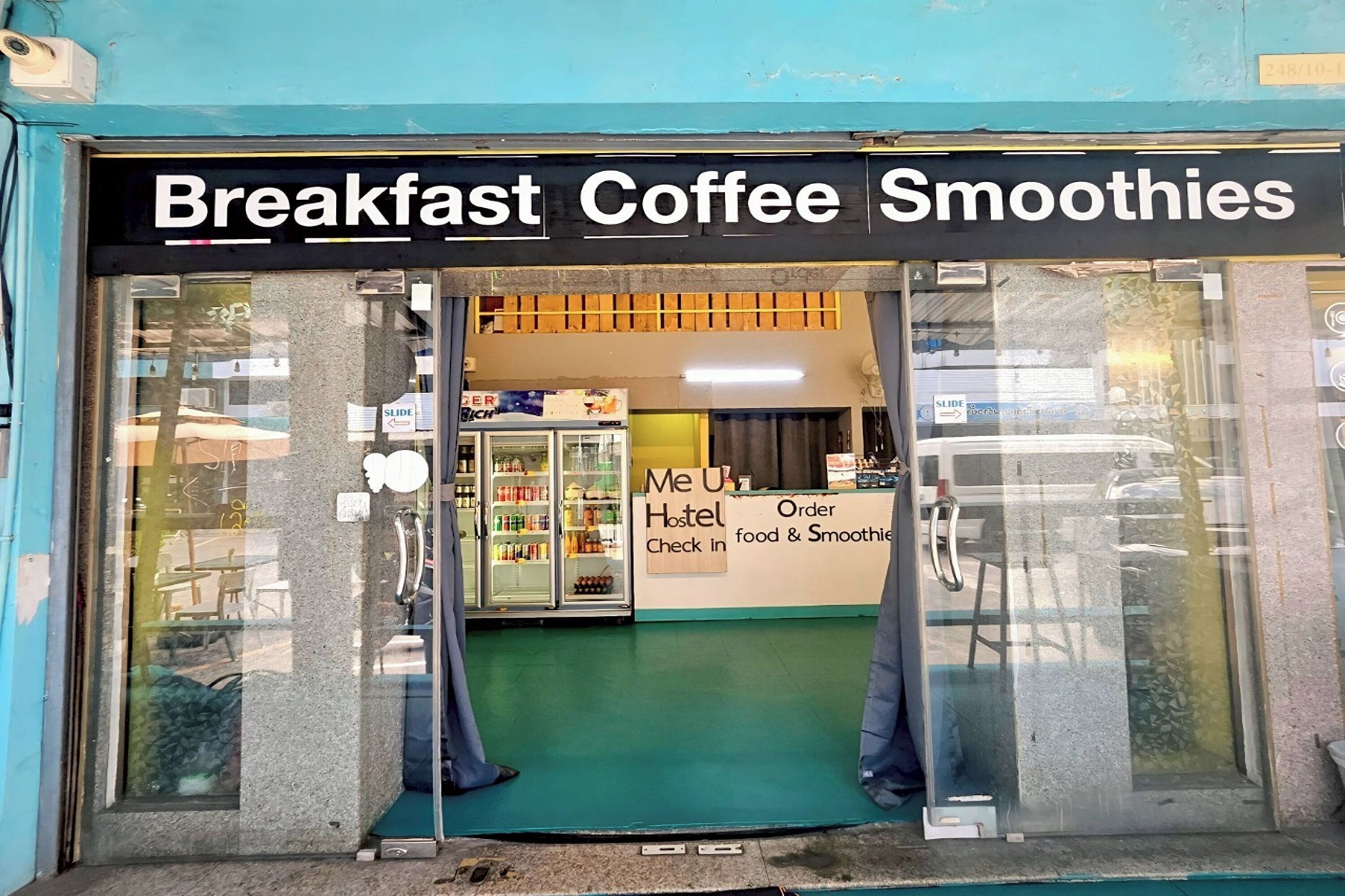 A storefront with a sign reading "Breakfast Coffee Smoothies."