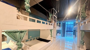A dormitory-style room with bunk beds, a ladder, and a window with curtains. - Me U Hostel (Chiang Mai)