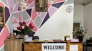 Un comptoir d’accueil avec une pancarte indiquant : « BIENVENUE, AMATEURS D’OSHO ».