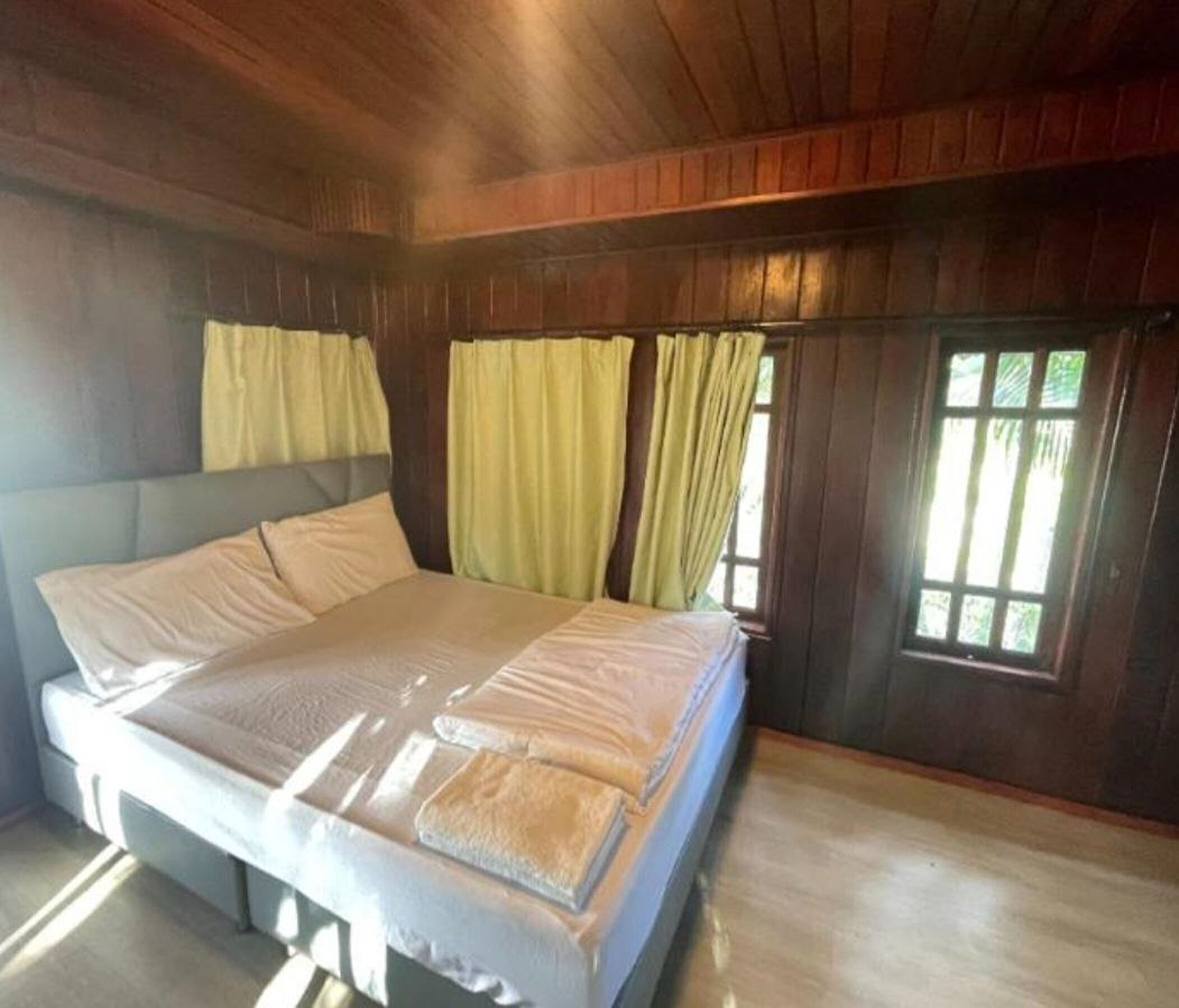 A bedroom with a bed, curtains, and a window.