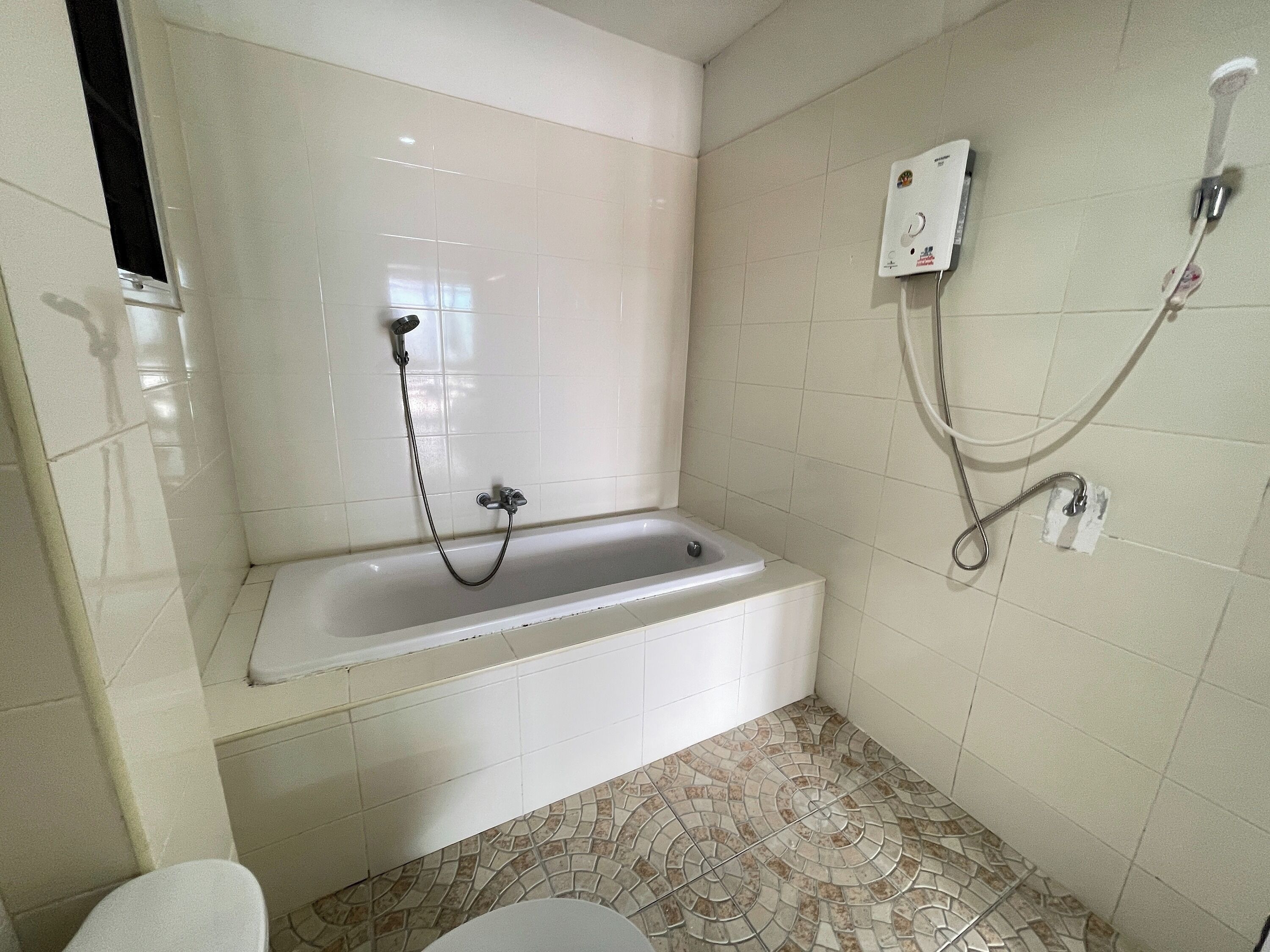 A bathroom with a bathtub, a shower, and a toilet.