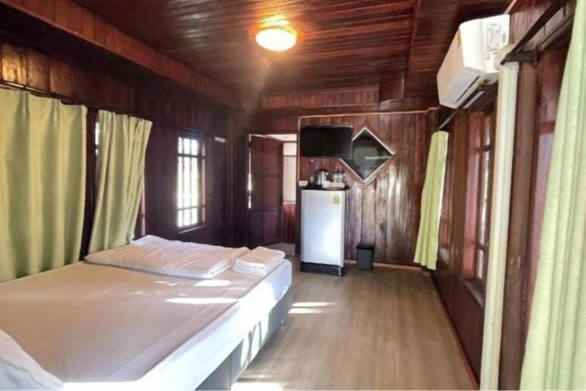 A room with a bed, a television, and a refrigerator.