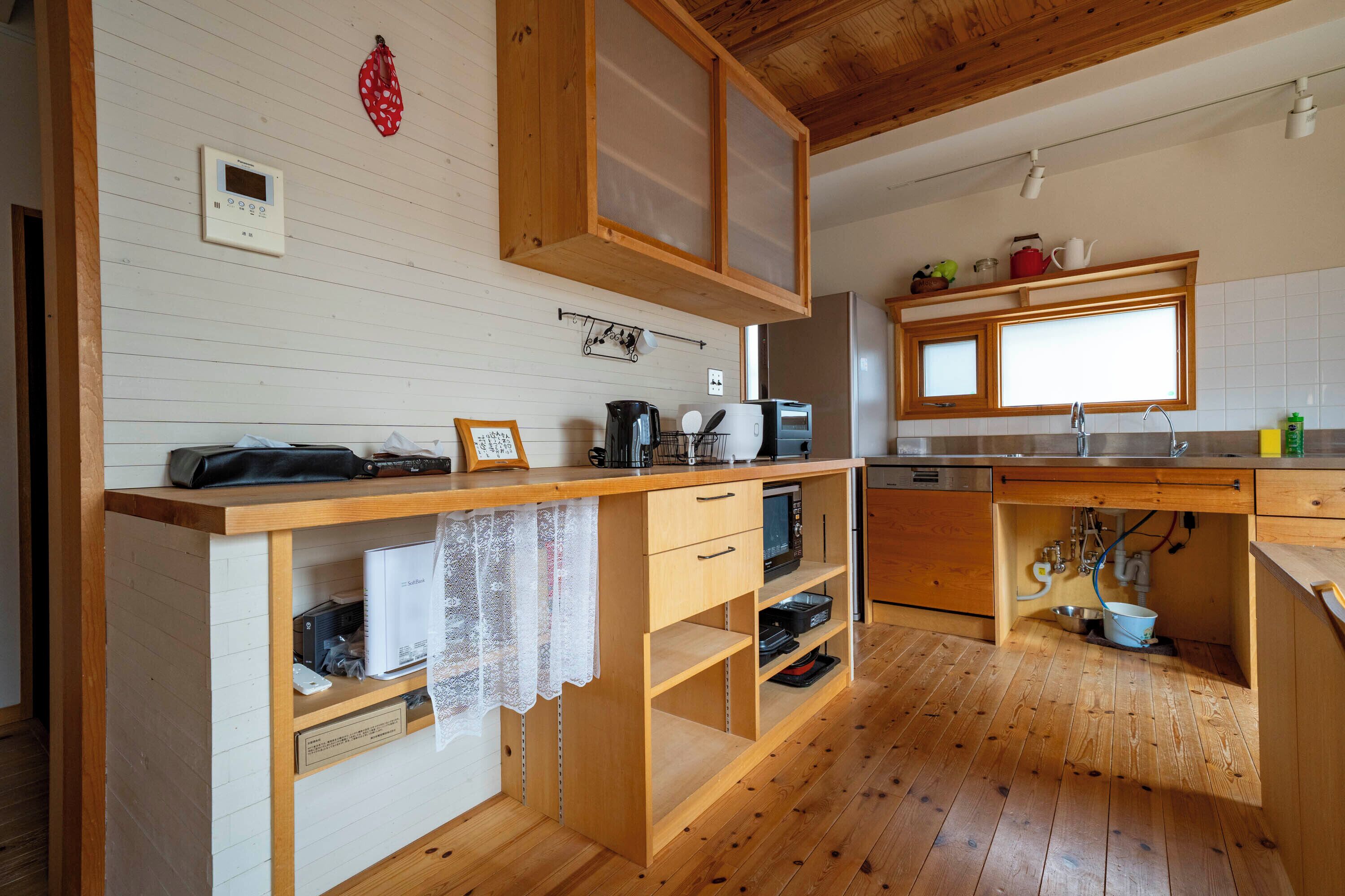 Una cocina con armarios de madera, microondas y fregadero.
