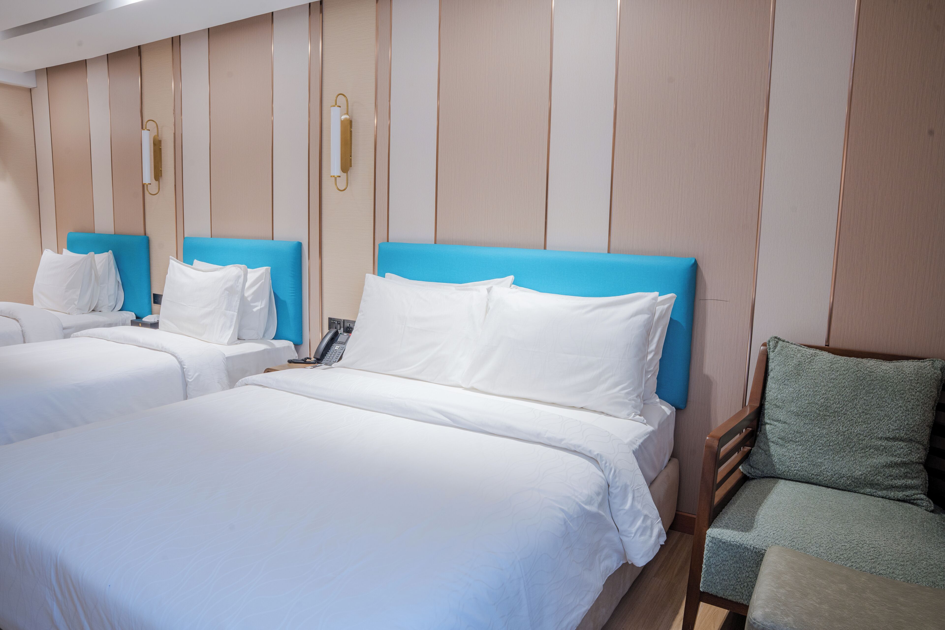 Een hotelkamer met twee bedden, een stoel en een telefoon.