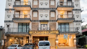 A multi-story hotel with balconies, a sign reading 'BELAJANERO HOTEL,' and a van parked in front. - Sunday Belajandro Hotel (Angeles City)