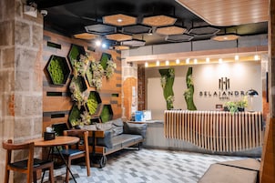 A hotel reception area with a modern design, including a reception desk, seating area, and decorative plants.