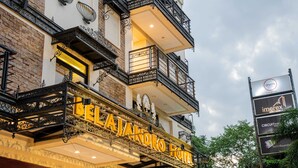 A hotel with ornate balconies, a prominent sign reading 'BELAJANDRO HOTEL,' and a signboard advertising 'imerex' and 'CIRCUITMINING.' - Sunday Belajandro Hotel (Angeles City)
