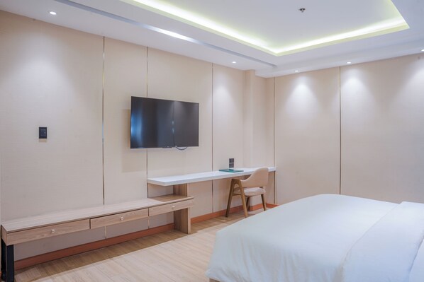 A modern bedroom with a bed, a desk, and a TV mounted on the wall. - Sunday Belajandro Hotel (Angeles City)
