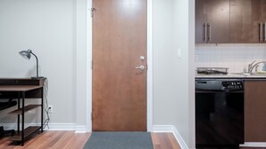 Una cocina con puerta de madera, lavavajillas y encimera con fregadero.
