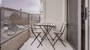 Un balcón con vistas a la ciudad, que incluye una mesa y dos sillas.