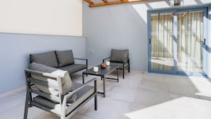 Un patio con un sofá, dos sillones y una mesa de centro.