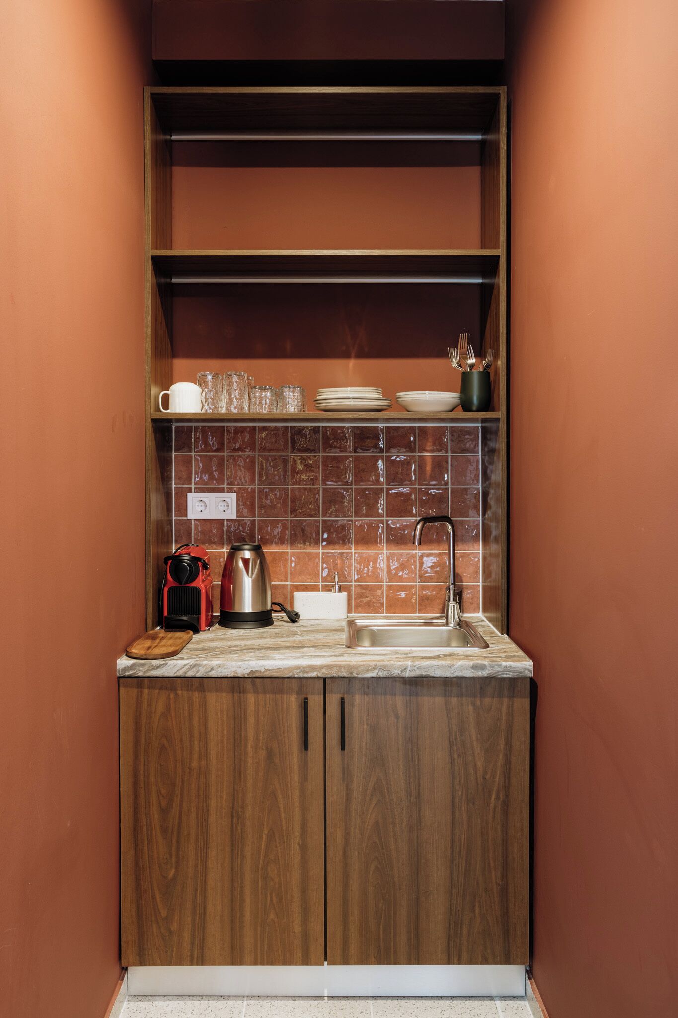 A compact kitchen with a wooden cabinet, a sink, and a tiled backsplash.