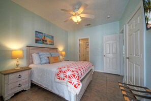 A bedroom with a bed, nightstands, a ceiling fan, and a door. - Sleeps 10 | Two Condos. Pet-Friendly + Beach access (Port Aransas)