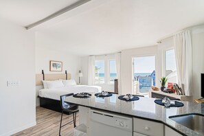 Relax in a spacious room with a large bed, separate dining area, and stunning sea views through large windows.