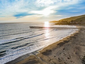 Walk along the beach to the wooden pier, where gentle waves lap at the shore.