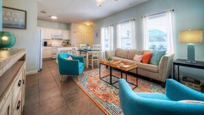 Un salon comprenant un canapé, des fauteuils, une table basse et un tapis.