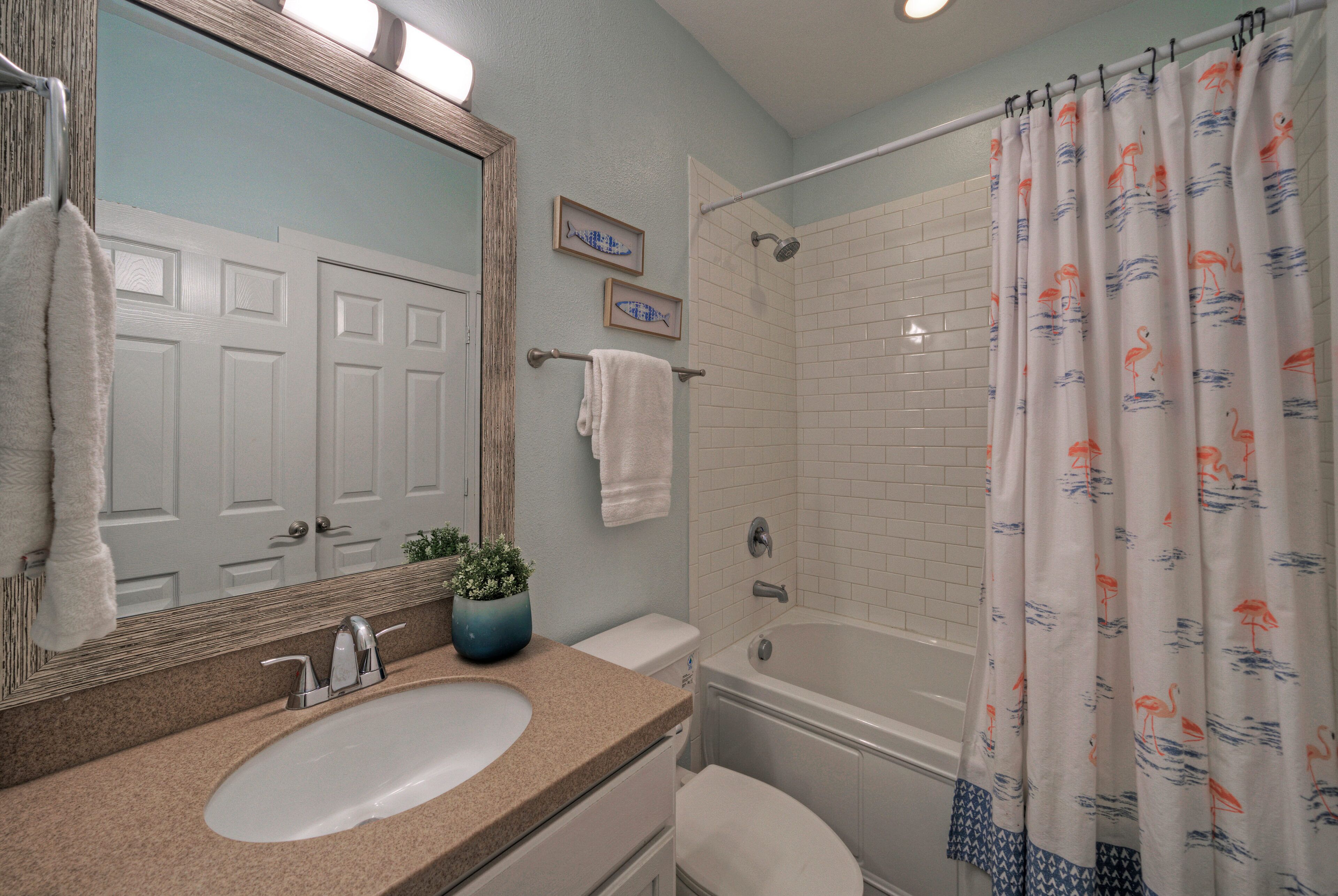Une salle de bain équipée d’un lavabo, d’un miroir, de toilettes et d’une baignoire.