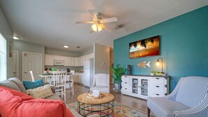 A living room with a sofa, armchairs, a coffee table, and a dining area with a table and chairs.